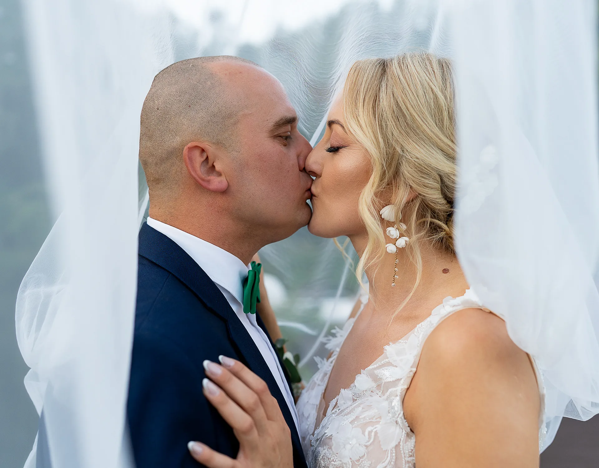 Pocałunek pary młodej pod welonem nad jeziorem — reportaż ślubny, fotograf Tobiasz Kaczmarczyk